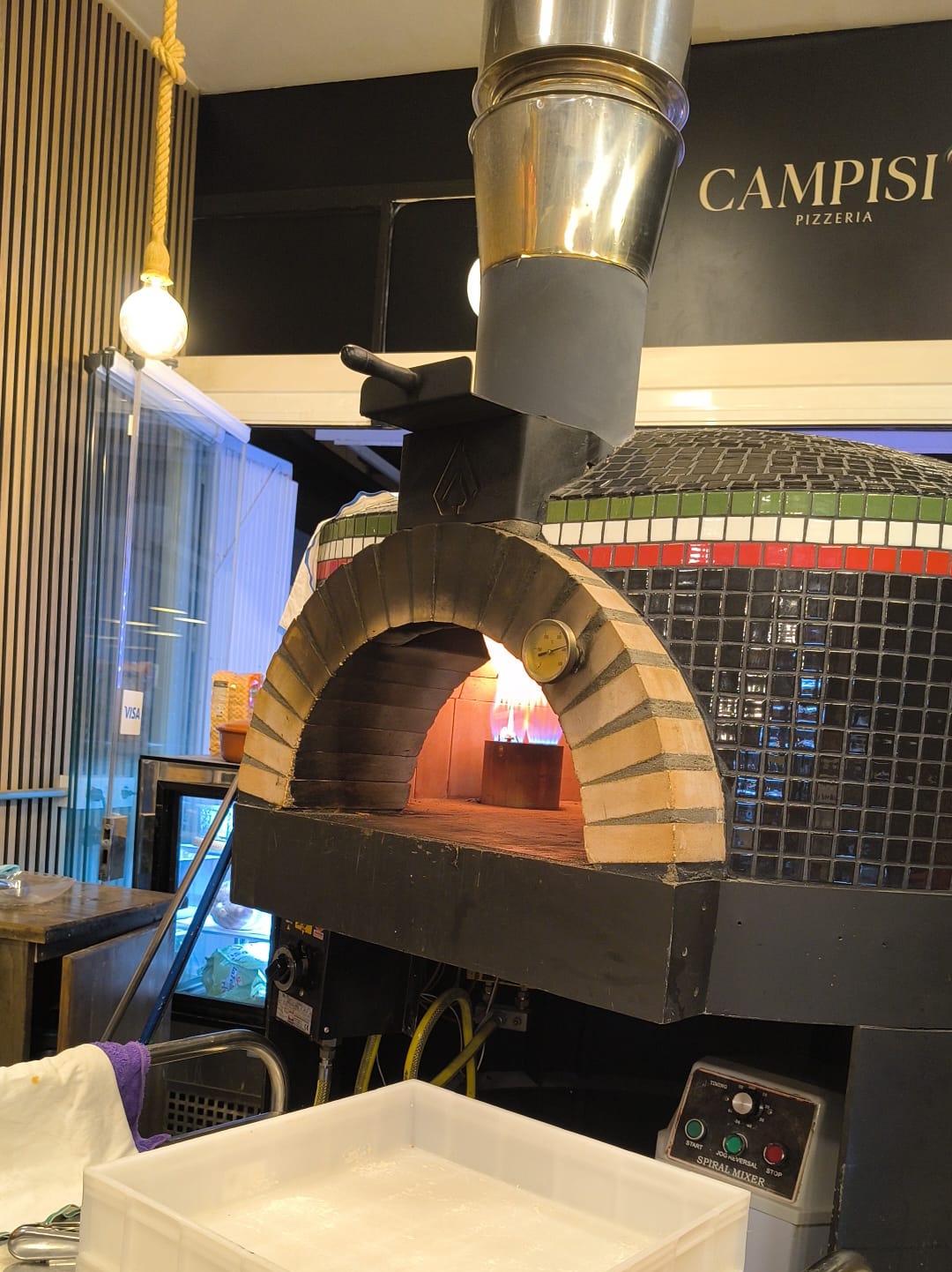Cosy interior of Desidero Pizzeria with wood-fired oven and timber finishes