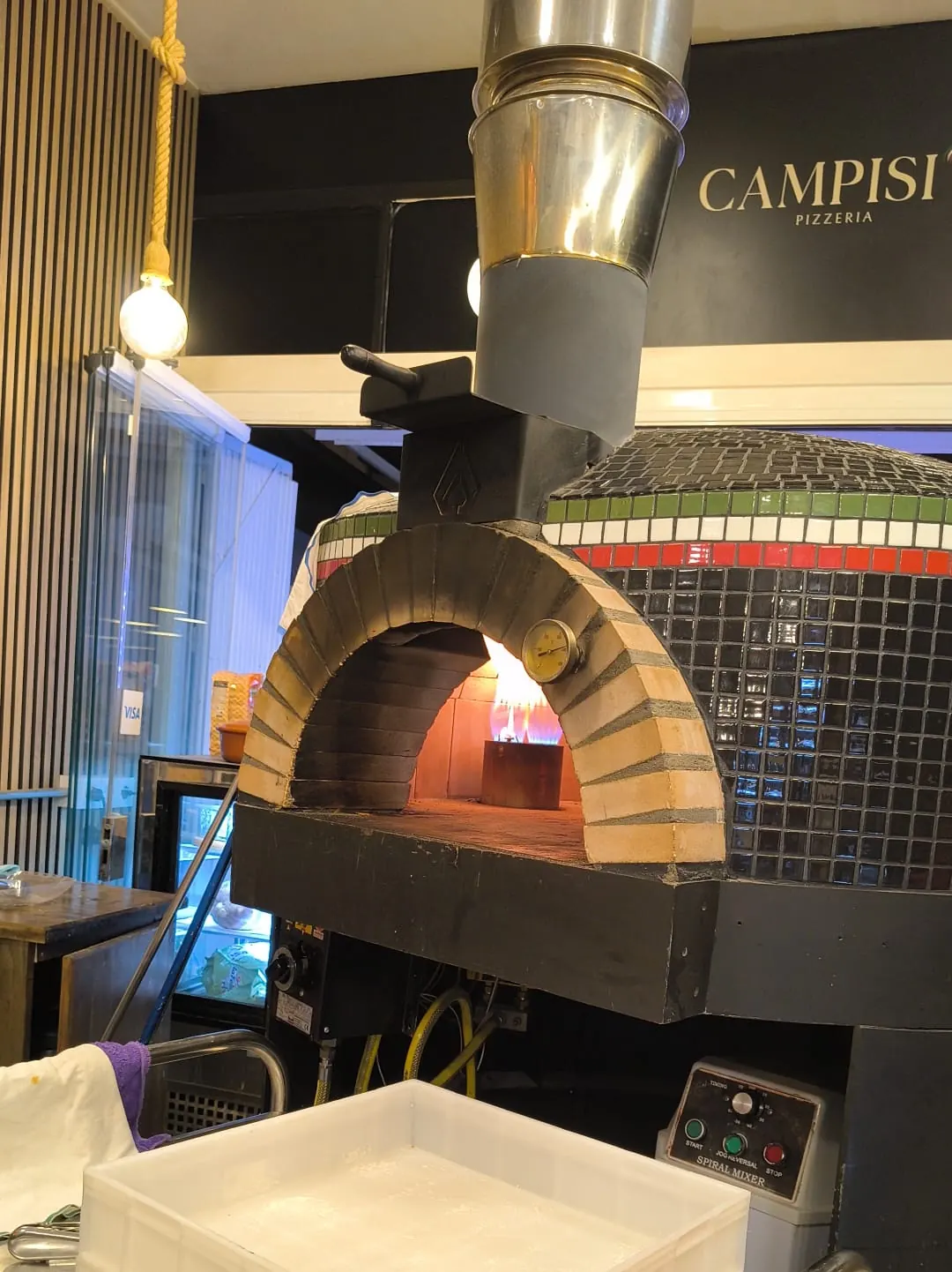 Interior acogedor de Desidero Pizzeria con horno de leña y acabados en madera